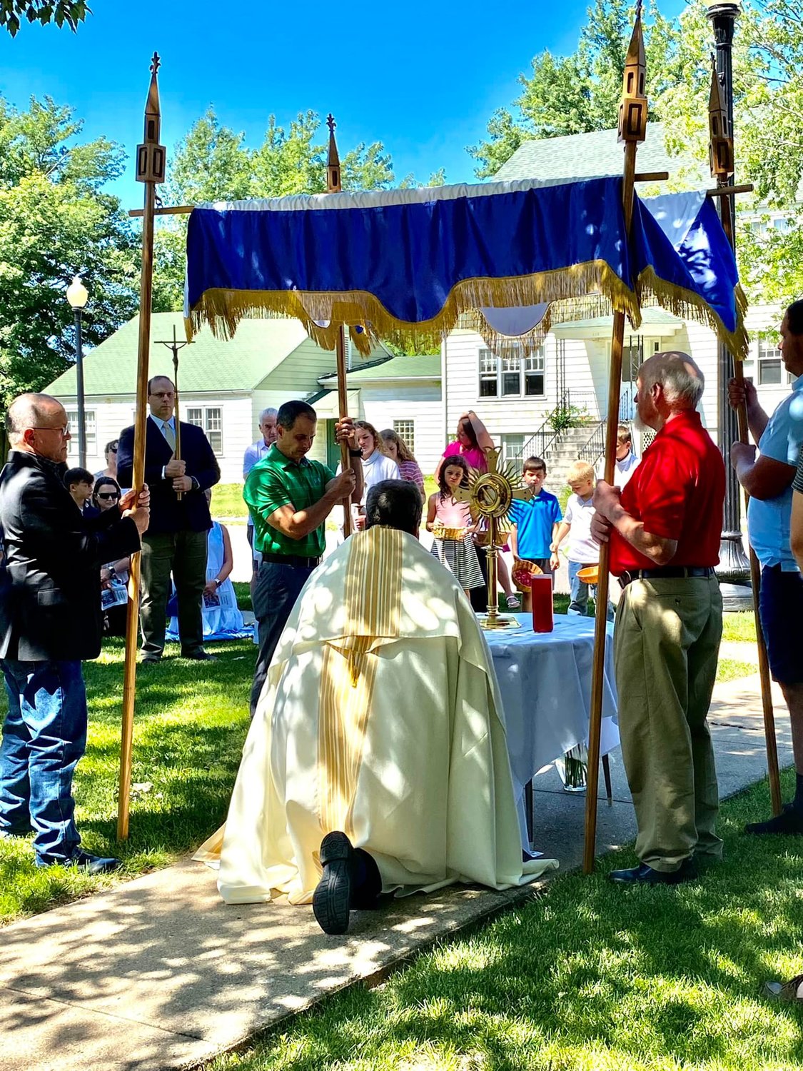 Father Gregory Oligschlaeger, pastor of Holy Rosary Parish in Monroe City and St. Stephen Parish in Indian Creek, reverences the Most Blessed Sacrament on one of three temporary altars near Holy Rosary Church during an outdoor Eucharistic procession on June 19, the Solemnity of the Most Holy Body and Blood of Christ.